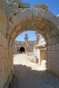 Utsikt genom den välvda ingången till Xanthos-teatern in i orkestergropen, med pelare och harpygrav, Xanthos, Turkiet (foto) av Roman