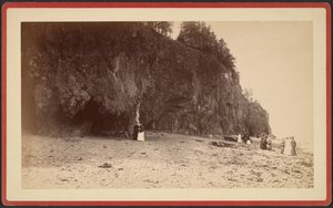 [Grupp människor på strandlinjen nära klippor, möjligen vid Mt. Desert, Maine] av S.R. Stoddard