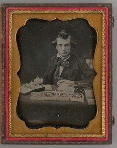 Utan titel porträtt av sittande man som håller en daguerreotypi och borste, 1865. av Samuel J. Miller