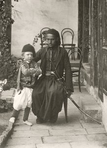 Arab kawass (ottomansk vakt) med en ung pojke i trädgården till ett hus i Judea-distriktet i Jerusalem, 1867