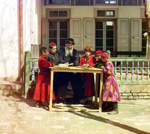En grupp judiska barn med en lärare på ett bord framför ett hus, Samarkand, ryska imperiet, mellan 1905 och 1915