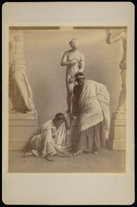 [Två manliga studenter i grekisk dräkt framför en gipsavgjutning av Afrodite i avgjutningsrummet på Pennsylvania Academy]. av Thomas Eakins