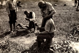 Österrikiska fångar under första världskriget i Bagnaria Arsa, Udine, Italien; i förgrunden rakar en soldat en medsoldat, 1916-04-02 (s/v foto)