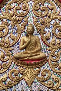 20151102, Vang Vieng, Laos : Entrédörr prydd med guldreliefer. The Teaching Buddha skildrar ett speciellt ögonblick i Buddhas liv, nämligen den första predikan som Buddha höll efter att ha nått upplysningen av Unbekannt