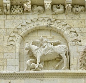 Romansk konst: detalj av fasaden som föreställer Hugues de Surgeres och Geoffroy de Vendome eller kejsar Konstantin I den store vars fot av hästen skulle trampa Heresie och Kristus triumferande av ondska och död, Notre Dame (Notre-Dame) de Surgeres (17700) av Unbekannt