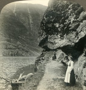 Där vägen kryper under de utskjutande klipporna vid vattnet i Nerofjorden, Norge, c1905. av Unbekannt