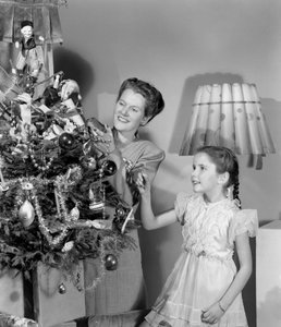 Kvinna och flicka dekorerar en julgran, c 1948 av Unbekannt