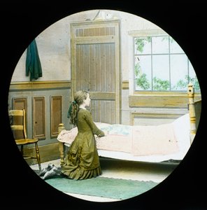 En flicka som ligger på knä i bön vid hennes säng, rutschkana för magisk lykta, ca 1890 av Unbekannt