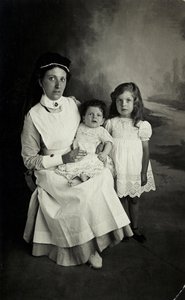 En "sköterska" poserar med barn på 1920-talet. av William M. Timlin