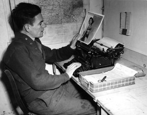 Andra världskriget (1939-1945) - Andra världskriget (WWII eller WW2): Mutzig (Alsace) Frankrike 1 december 1944: Korpral Flanertys krönikör vid Beachead News (GI:s nyhetstidning) tittar på ett pin-up fotografi som han publicerar i nästa nummer av tidningen av Unbekannt