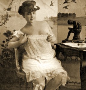 Ung kvinna som visar en spetsad chemise, c.1900 av Unknown
