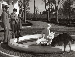 Gino Bartali med två barn och en hund nära en fontän av Unknown photographer