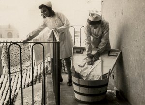 Några kvinnor är upptagna med att tvätta sig på den kvinnliga yrkesutbildningsskolan "Regina Elena" di Imola, idag högstadieskolan "Innocenzo da Imola" av Unknown photographer