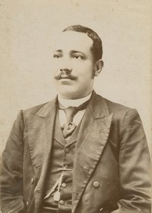 Fotografi av en man klädd i mörk kostym med fickur i västen, 1886-1900. av W. M. Hubbard