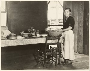 [Elizabeth Tengle vid köksbordet]/[Paralee Ricketts arbetar i köket] av Walker Evans