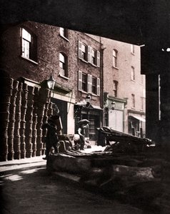 Fruktkorgar staplade mot hus på Borough Market, London, 1926-1927