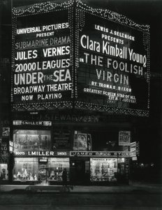 1554 Broadway på 46th Street, I. Miller Shoes; James Drug Store och stora tält för filmer lyser upp ovan. av William Davis Hassler