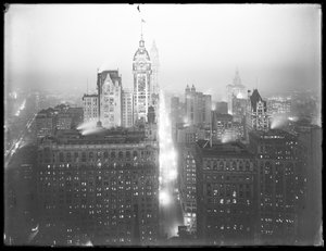Nattens dimmiga vy av nedre Manhattan i norr, med Singer Building, Woolworth Building och Municipal Building synliga, ca 1913. av William Davis Hassler