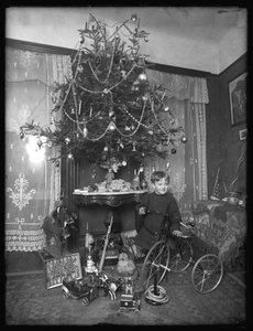 Pojke från Seymour med trehjuling vid julgranen i salongen, julen 1912