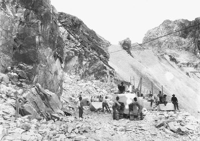 Grävare i arbete vid ett marmorbrott i Apuanska Alperna, Toscana. Några av dem sitter på marmorblock som redan är avjämnade. (svart/vitt foto) av A. Corsini