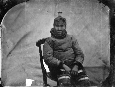 En äldre inuk-kvinna sitter i en stol av Admiral Edward Augustus Inglefield