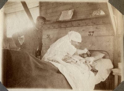 Första världskriget 1914-1918: sjuksköterska i blus rakar en soldat (franska krigssår ligger i en säng), i Couville, Manche, Basse-Normandie (Lagre Normandie), Frankrike. Anonymt fotografi juli 1917. Privat samling, Stella. av Anonymous Anonymous