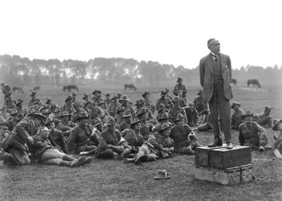Den höge ärade William Morris (Billy) Hughes, stående på en plattform som består av fyra ammunitionslådor, talar till en sammankomst av den 5:e australiska fältambulansen, nära La Motte, cirka ett kilo av Australian Photographer