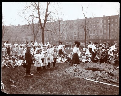 Vuxna och barn med flaggor runt ett nygrävt hål för en trädplantering på Arbor Day i Tompkins Square Park, New York, 1904 (silvergelatintryck). av Byron Company