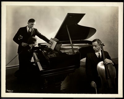Blind kvinna, Miss Harding, vid pianot och instruerar två blinda män i fiol och cello, 1936 (silvergelatintryck) av Byron Company