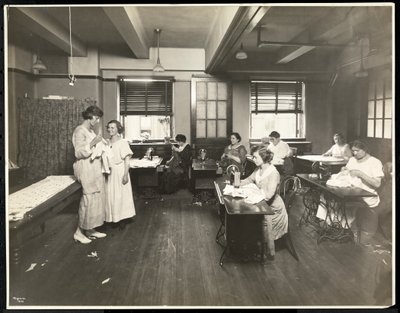 Blinda unga kvinnor och en lärare syr i ett klassrum på New York Association for the Blind, 111 East 59th Street, New York, 1921 (silvergelatintryck). av Byron Company