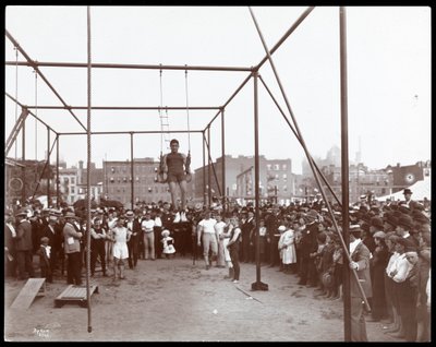 En folkmassa tittar på en gymnast vid Hudson Bank Gymnasium and Playground, 53rd Street och 11th Avenue, New York, 1898 (silvergelatintryck) av Byron Company