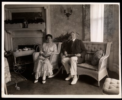 Porträtt av Mr. och Mrs. Howard sittande poserade i ett vardagsrum i deras hem på 200 5th Avenue, New York, 1916-6 (silvergelatintryck) av Byron Company