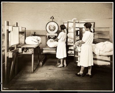 Två afroamerikanska kvinnor som väger påsar med tvätt på Carolyn Laundry på 111 East 128th Street, East Harlem, New York, 1928 (silvergelatintryck) av Byron Company