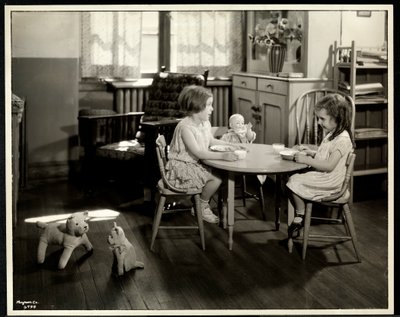Två blinda synskadade flickor äter vid ett litet bord med en docka på New York Association for the Blind, 111 East 59th Street, New York, 1933 (silvergelatintryck) av Byron Company
