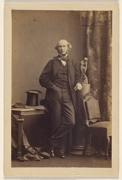 [Oidentifierad man står, hög hatt på bordet] av Camille Silvy