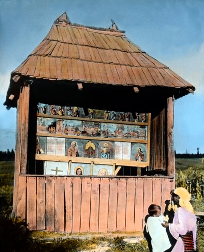 Rumänien, Bukovina, mor med barn framför ett litet kapell med bilder av helgon, bilddatum: ca 1920. Carl Simon-arkivet av Carl Simon