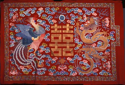 En kinesisk hängning av röd ull med en central karaktär i förgylld tråd flankerad av en Phoenix och en drake, 1800-tal av Chinese School