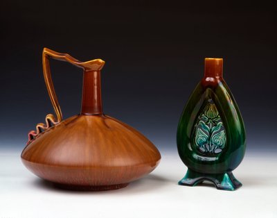 En Linthorpe keramikkanna av komprimerad klotform med strimmig karamell, grön och crimson glasyr och en Linthorpe Pottery vas med genomborrad blomknoppsdekor och fläckiga gröna, blå och bruna glasyrer av Christopher Dresser