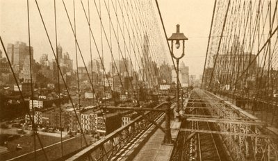 Lower Manhattan sett genom nätverket av kablar på Brooklyn Suspension Bridge, c1930. av ENA