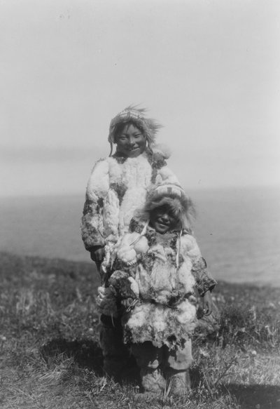 Ett litet barn och en äldre Eskimo som bär anka hudparkas, Nunivak Island, Alaska, c.1929 (b/w foto) av Edward Sheriff Curtis