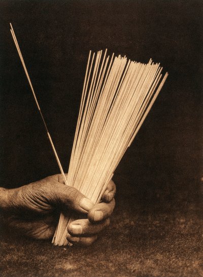 Närbild av handen på en indian från Hupa-stammen eller -byn som håller i spådomsstavar av Edward Sheriff Curtis
