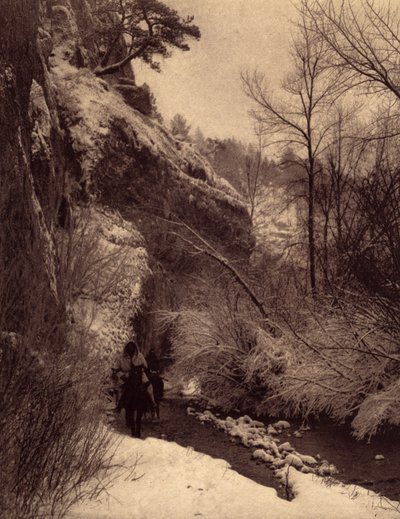 Passerar klippan, vinterscenen. Apsaroke-indianer som rider längs en klippa i snön på Pryor River, Montana. Foto taget från volym 4 av uppslagsverket publicerat av Edward S. Curtis (1868-1952) om indianerna i Nordamerika, med ett förord av Theo av Edward Sheriff Curtis