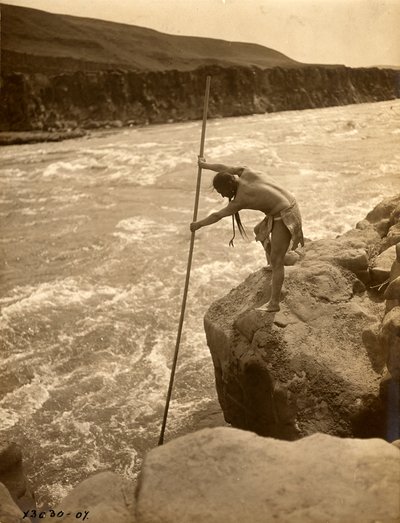 Tlakluit-indian, stående på klippa, fiskar med håv, ca 1910 (svartvitt foto) av Edward Sheriff Curtis