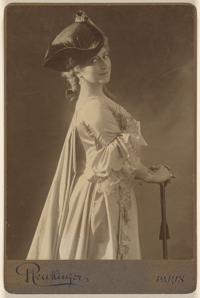 [Oidentifierad kvinna med mörk hatt, stående, med händerna vilande på en käpp] av Emile Auguste Reutlinger