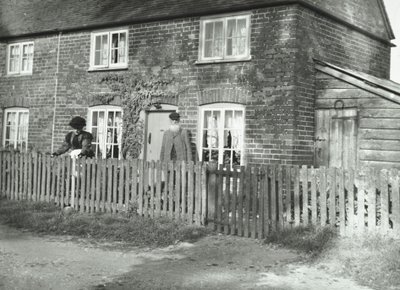 En lantlig scen i Wandsworth-området med ett äldre par i trädgården på en fastighet i stugstil, London, 1895 av English Photographer