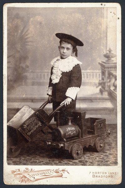 Pojke med ett leksakståg och skottkärra av English Photographer