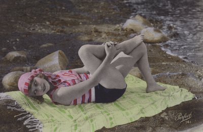 Flicka som ligger på handduken på stranden (färgat foto) av English Photographer