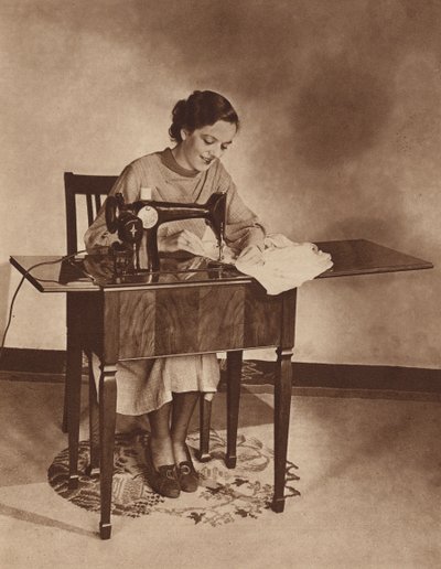 Hemmafru i arbete vid symaskinen, mitten av 1930-talet (svartvitt foto) av English Photographer