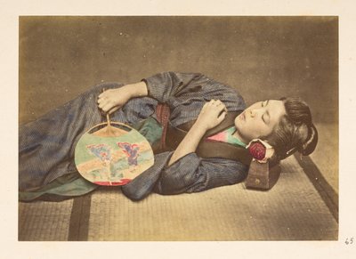 Japansk kvinna sover, Tre fjärdedels studioporträtt av en ung japansk kvinna som sover, håller en fläkt i höger hand och med huvudet vilande på en träkudde,   Fotograf: Okänd  Lucas Collection: Fotografisk rekord av världen t av English Photographer
