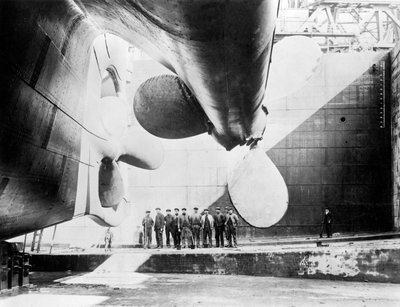 Arbetare som står under en av propellrarna på Titanic, 31 maj 1911. av English Photographer